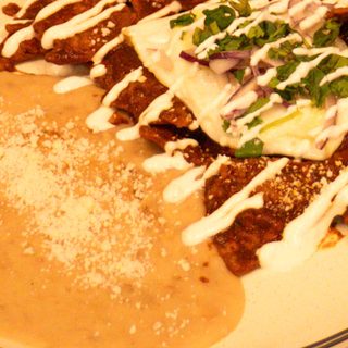 Chilaquiles rojos with a fried egg, crema, and cotija